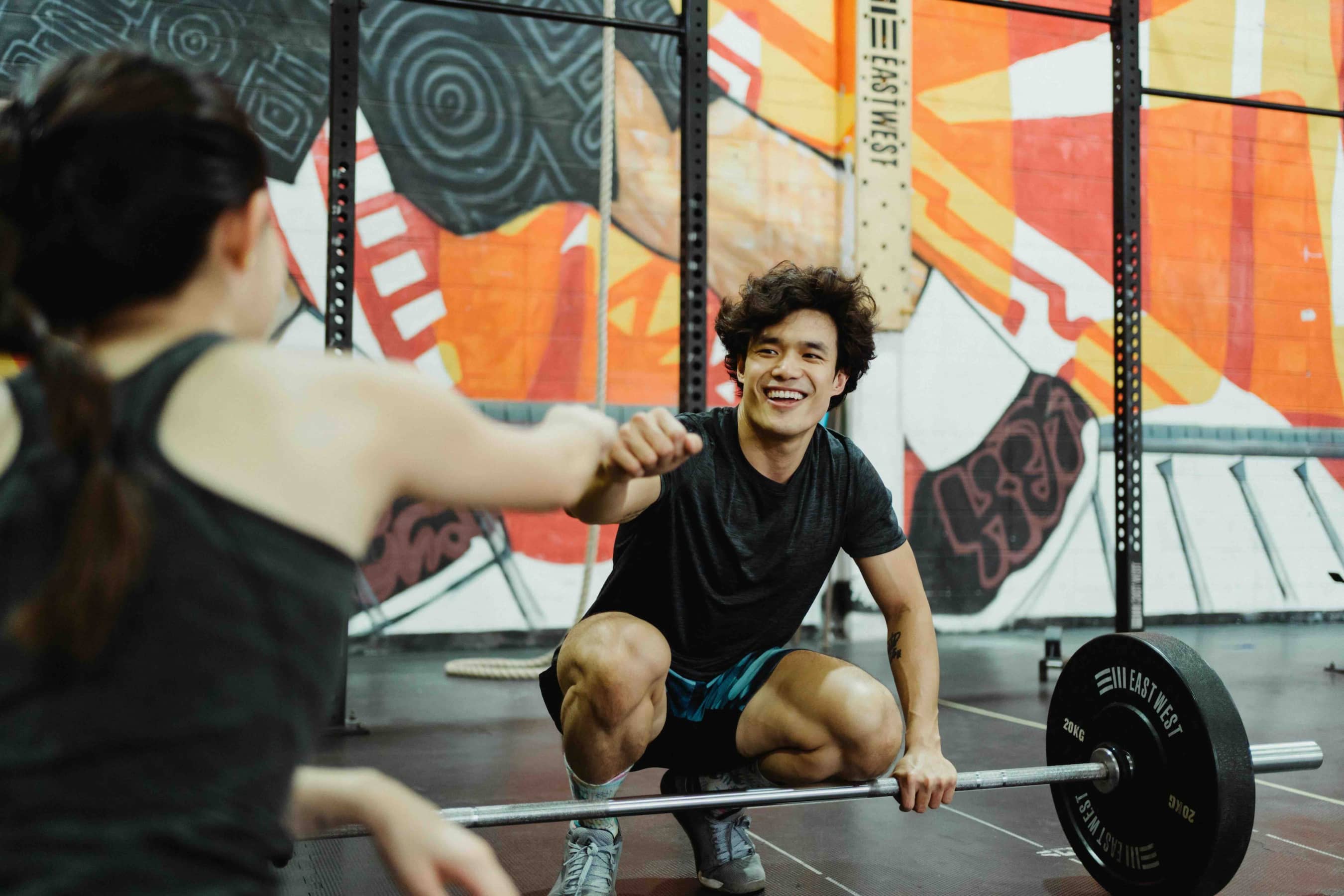 Two people sharing a fist-bump at the gym